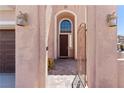 Arched entryway of home with paver flooring and decorative lighting at 10478 Beallsville St, Las Vegas, NV 89141
