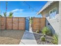 Attractive front yard with desert landscaping, modern horizontal wood slat fence, and decorative string lights at 105 Shadow Ln, Las Vegas, NV 89106