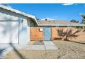 Attractive front yard with desert landscaping and a modern, horizontal wood slat fence and entry gate at 105 Shadow Ln, Las Vegas, NV 89106