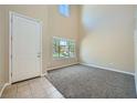 Bright entryway with tile flooring, carpeted living area, and a large window, creating a spacious and inviting atmosphere at 10693 Harvest Green Way, Las Vegas, NV 89135