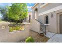 Exterior of the home showcasing a tiled wall, wrought iron fence, and desert landscaping at 11901 Luna Del Mar Ln, Las Vegas, NV 89138
