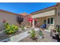 Private courtyard oasis with comfortable seating, lush greenery, and a red umbrella for shade at 2456 Desert Butte Dr, Las Vegas, NV 89134