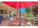 Charming courtyard patio with red umbrella providing shade for an outdoor dining set at 2456 Desert Butte Dr, Las Vegas, NV 89134