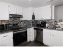 Modern kitchen featuring white cabinets, stainless steel appliances, and stylish backsplash at 2921 Country Manor Ln # 139, Las Vegas, NV 89115