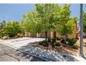 Street view of a home featuring beautiful shade trees and lush landscaping creating a welcoming atmosphere at 3773 Blake Canyon Dr, North Las Vegas, NV 89032