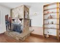 Living room featuring a stone fireplace, hardwood floors and built-in shelves at 4458 El Quinta Ct, Las Vegas, NV 89121