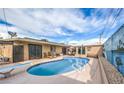 Backyard pool features patio area for outdoor dining and relaxing, with a painted wall accent at 5093 Sun Valley Dr, Las Vegas, NV 89122