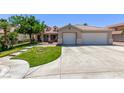 Inviting single-story home with a three-car garage and a lush green lawn at 6307 Dusty Mile Ct, North Las Vegas, NV 89031