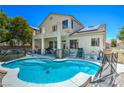 Backyard featuring a refreshing kidney-shaped pool and covered patio, perfect for outdoor entertaining at 7537 Splashing Rock Dr, Las Vegas, NV 89131