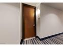 Condo front entrance with striped blue carpet, wood door and modern sconce lighting at 8255 Las Vegas Blvd # 809, Las Vegas, NV 89123