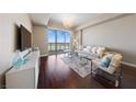 Bright and airy living room featuring hardwood floors and access to a private balcony with mountain views at 8255 Las Vegas Blvd # 809, Las Vegas, NV 89123