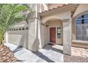 Close-up of a home's entrance featuring a red door and attached two-car garage at 8712 Texas Bronco Ave, Las Vegas, NV 89129