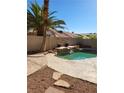 Backyard pool featuring a rock waterfall and mature landscaping, perfect for outdoor relaxation at 8712 Texas Bronco Ave, Las Vegas, NV 89129