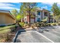 Exterior view of an apartment building featuring lush landscaping and ample parking at 913 Duckhorn Ct # 201, Las Vegas, NV 89144