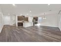 Open-concept living space with wood floors, neutral paint, modern lighting, and an adjacent kitchen at 9327 Ettrick Ct, Las Vegas, NV 89178