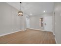 Spacious living room with light hardwood floors and a contemporary light fixture at 9513 Yucca Blossom Dr, Las Vegas, NV 89134