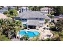 Aerial view of a home featuring a private pool with spa and lush tropical landscaping, creating a backyard oasis at 9905 Fox Springs Dr, Las Vegas, NV 89117