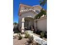 Charming front entryway features a covered porch, decorative iron door, and a well-manicured garden at 9940 Trailing Vine St, Las Vegas, NV 89183