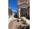 Inviting front entrance with covered porch, decorative accents, and a neatly landscaped garden area at 9940 Trailing Vine St, Las Vegas, NV 89183