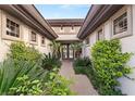 Lush landscaping adorns the entryway of this bright home with a walkway leading to the front door at 1 Dry Brook Trl, Henderson, NV 89052