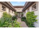 Inviting entryway adorned with lush greenery, leading to a charming residence with custom iron doors at 1 Dry Brook Trl, Henderson, NV 89052