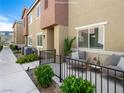A patio with seating and a black metal fence provides an inviting outdoor living space at 12112 Polar White Ct # 3, Las Vegas, NV 89183