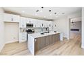 Bright kitchen with white cabinets, marble countertops, and stylish center island at 1312 Pacific Terrace Dr, Las Vegas, NV 89128