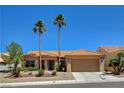 Traditional single-story home showcasing a two-car garage, tile roof, and well-maintained front yard at 3120 Darby Falls Dr, Las Vegas, NV 89134
