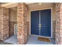 Welcoming home entrance featuring a blue double door framed by stone pillars and a 'welcome' mat at 5889 Wildhorse Ledge Ave, Las Vegas, NV 89131