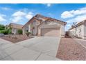 Inviting single-story home with a tile roof, two-car garage, and desert landscaping at 632 Hitchen Post Dr, Henderson, NV 89011
