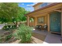 Cozy front porch with seating area and teal colored door and wreath at 6713 Guidestar St, North Las Vegas, NV 89084