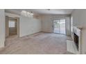 Open living room features a fireplace, high ceilings with skylights, and a sliding glass door to the yard at 7212 Nordic Lights Dr, Las Vegas, NV 89119