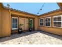 Private courtyard with string lights, neutral stucco walls, an artisan brick floor, and double front doors at 7914 Elk Mountain St, Las Vegas, NV 89113