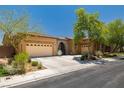 Exterior shot of a single story stucco home with a tile roof, desert landscaping, and an attached three-car garage at 7914 Elk Mountain St, Las Vegas, NV 89113