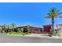 View of the home's entrance and front of the property with a driveway gate and mature landscaping at 8574 Verde Park Cir, Las Vegas, NV 89129