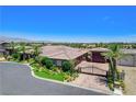 A high angle of the house, driveway and entrance gate and the mountains in the background at 8574 Verde Park Cir, Las Vegas, NV 89129