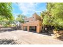 Rear view of a home featuring a three-car garage, staircase, and rooftop terrace at 10445 Schirlls St, Las Vegas, NV 89141