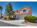 Inviting two-story home with a large front yard, a two-car garage, and mature landscaping at 1048 Menands Ave, Las Vegas, NV 89123