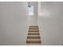 Well-lit stairway with a small window and neutral carpeting at 10550 W Alexander Rd # 2220, Las Vegas, NV 89129