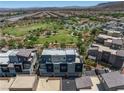 An aerial view of a community showcasing modern townhomes, lush green spaces, a playground and scenic mountain views at 11239 Cactus Tower Ave # 102, Las Vegas, NV 89135