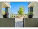 Front entrance view through gated stucco wall showcasing stone walkway, landscaping, and mountain views at 11239 Cactus Tower Ave # 102, Las Vegas, NV 89135
