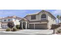 Classic two-story residence with a double garage, manicured shrubbery, and an attractive exterior color scheme at 1877 Glory Lily Ct, Las Vegas, NV 89123