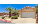 Home exterior featuring a two car garage door, desert landscaping, and palm tree at 2035 E Warm Springs Rd # 1019, Las Vegas, NV 89119