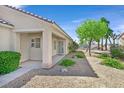 Inviting front entrance with a covered porch, desert landscaping and a secure screen door at 2548 Leighton Ave, Henderson, NV 89052