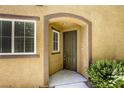 Welcoming arched entryway with a modern door, sidelight window, and manicured landscaping at 3905 Sweet Pine St # 102, Las Vegas, NV 89108