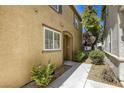 Side view of townhome featuring manicured landscaping, walkway, and neutral color at 3905 Sweet Pine St # 102, Las Vegas, NV 89108