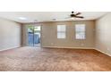 Spacious living room featuring neutral walls, plush carpet and a sliding glass door to the outdoor area at 3905 Sweet Pine St # 102, Las Vegas, NV 89108