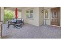Inviting front porch with stone pavers, an outdoor dining set, and a decorative door at 444 Middlestone Ave, Henderson, NV 89011