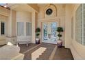 Charming front porch with decorative glass front doors, stylish planters, and a cozy bench at 4936 Mountain Foliage Dr, Las Vegas, NV 89148