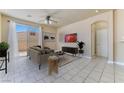 Bright living room with neutral walls, tile flooring, ceiling fan, and sliding glass doors at 5031 Droubay Dr, Las Vegas, NV 89122